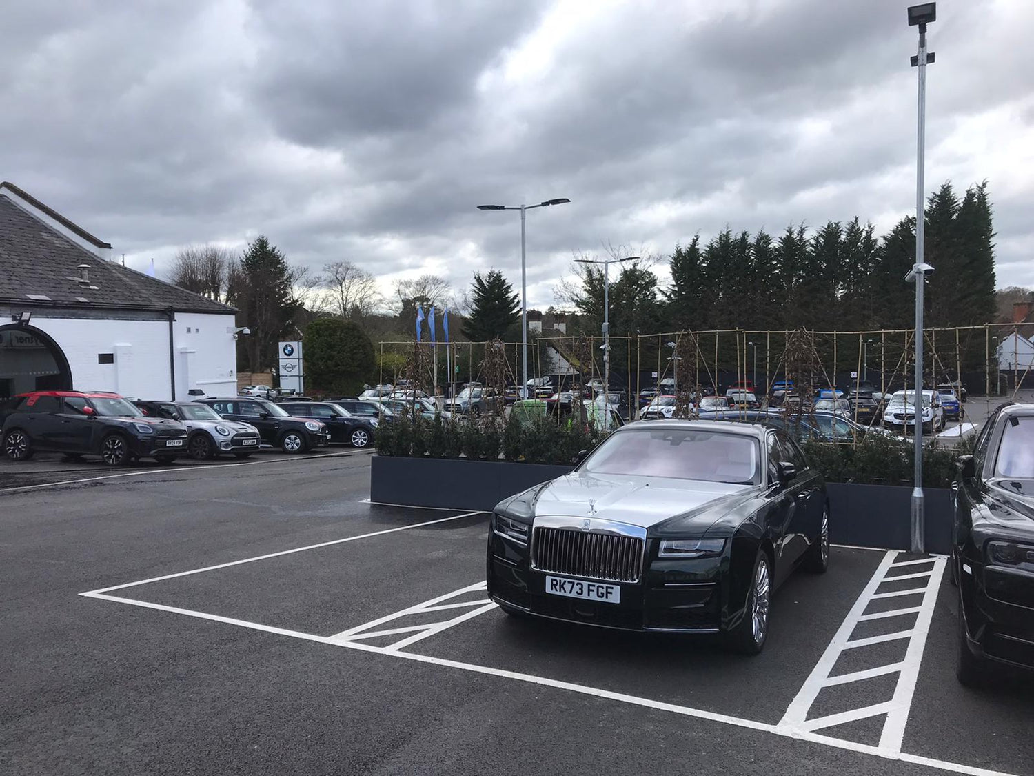 Grey, aluminium, powder coated planter in the car park of a Rolls Royce car park