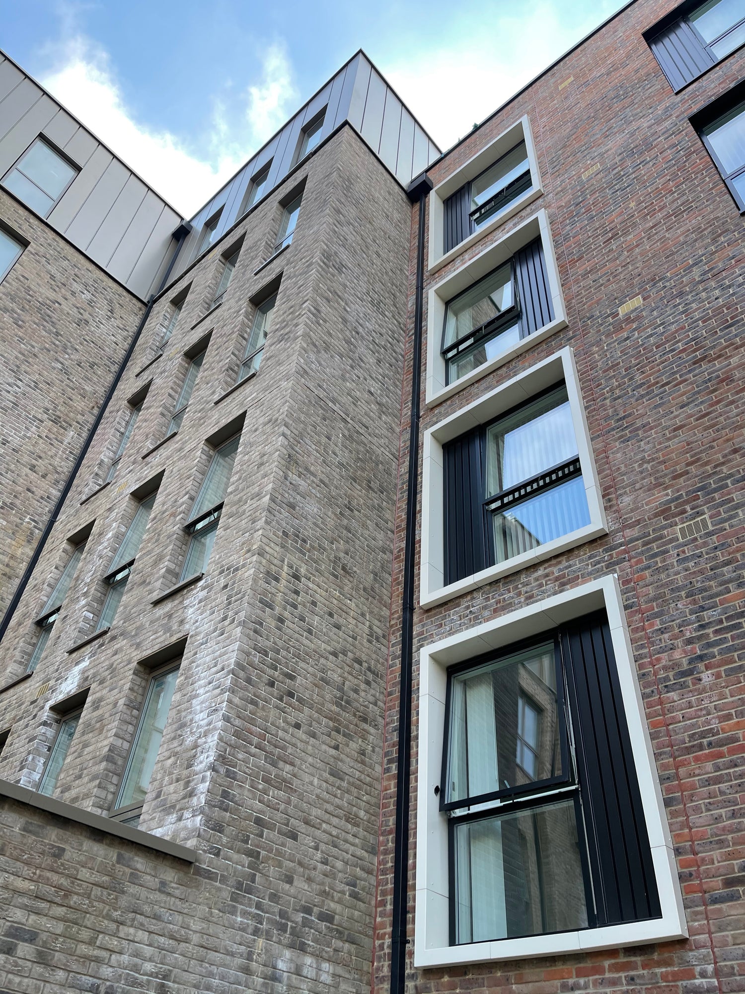 Black and white powder coated aluminium window surround on new build brick apartments