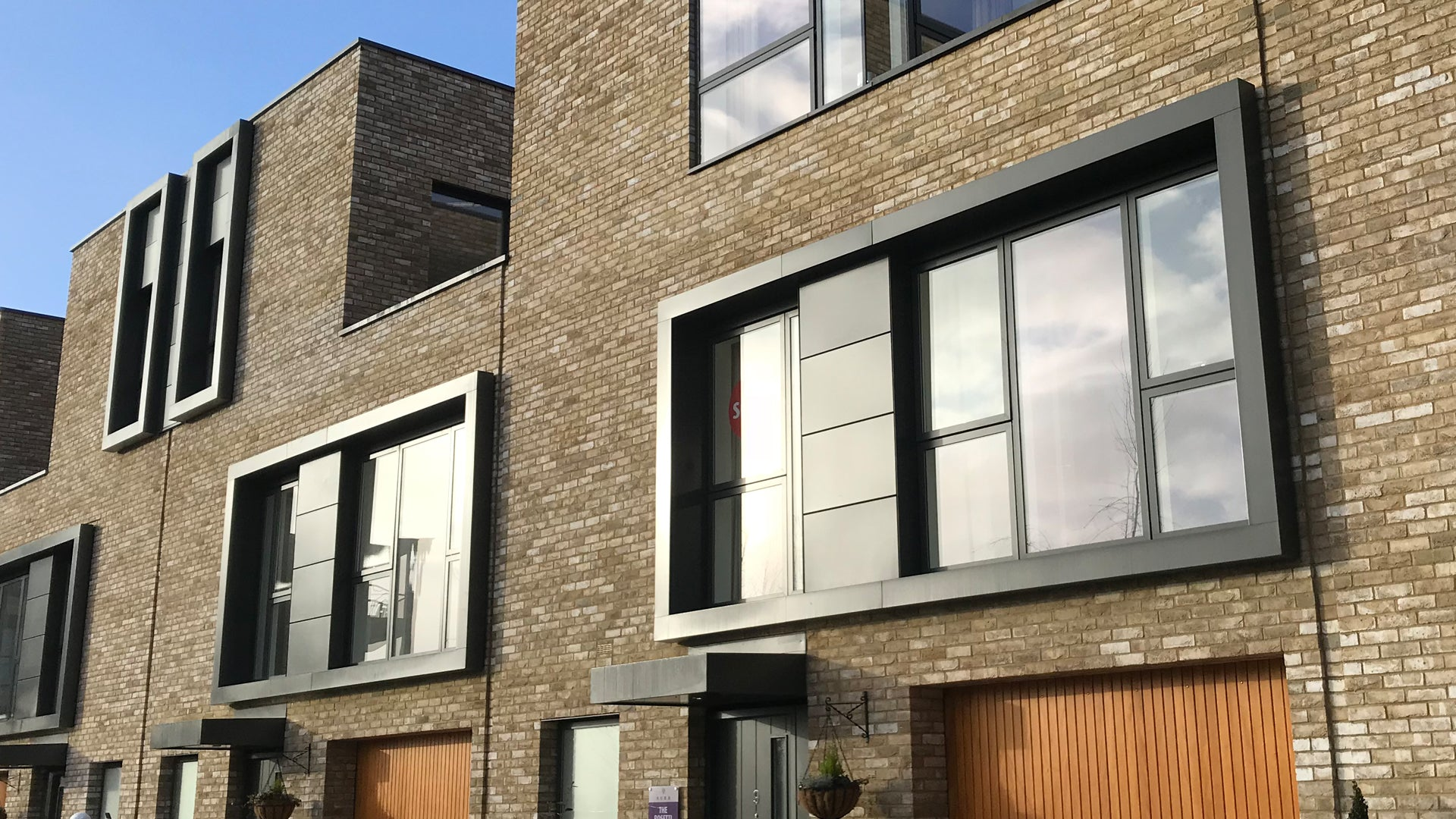 Black, powder coated aluminium window pod on new brick apartment building