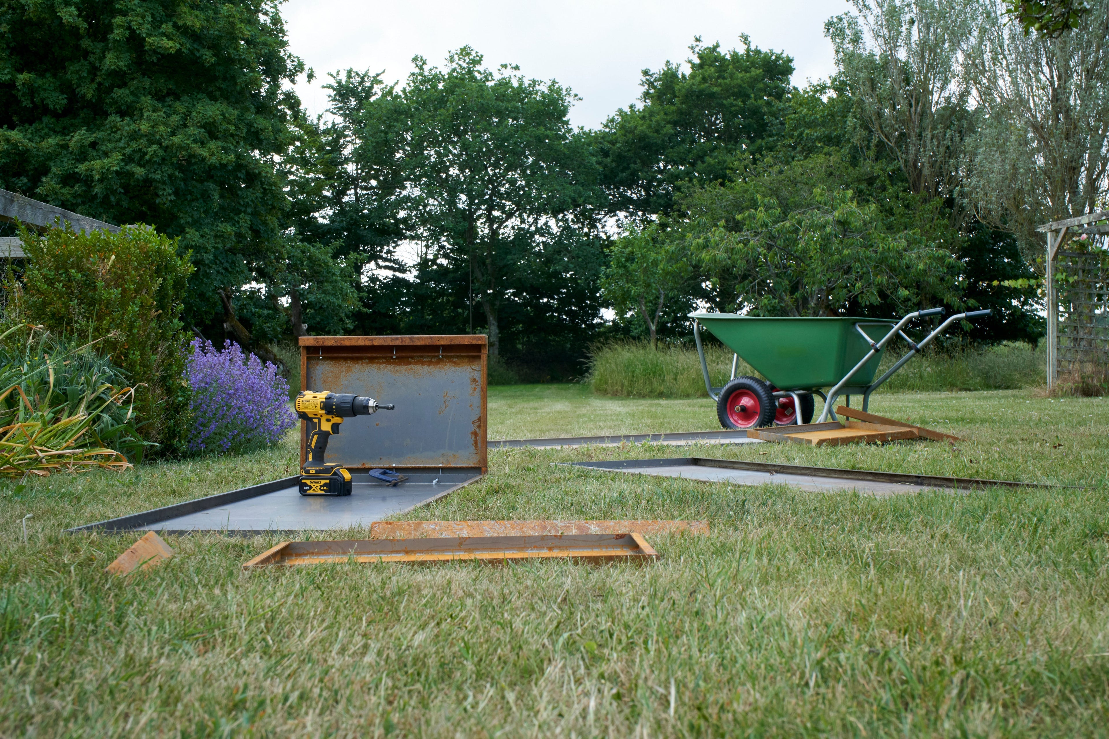 The assembly of Corten steel planters in a garden setting