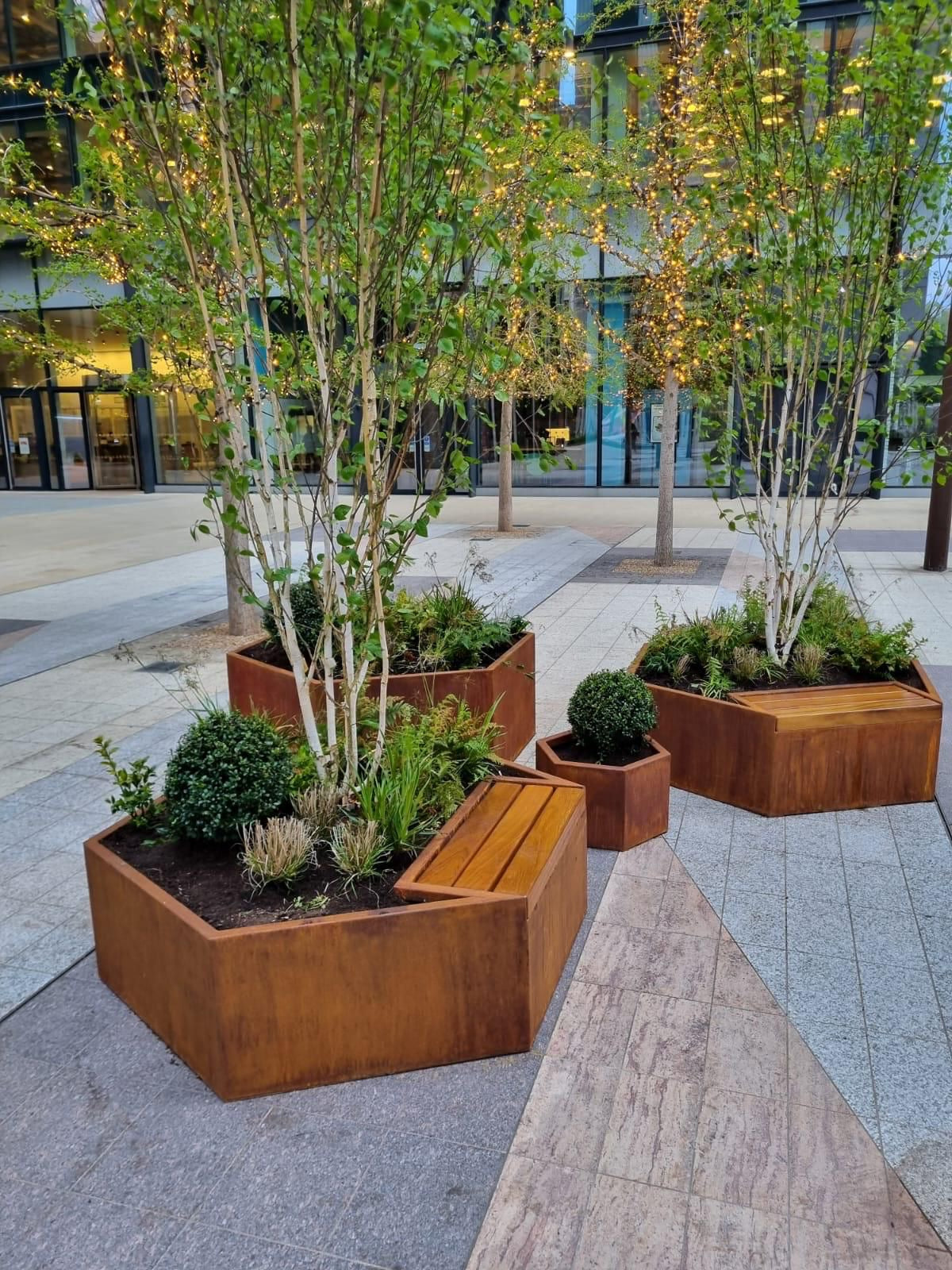 Hexagonal Corten steel planters with integrated benches in London